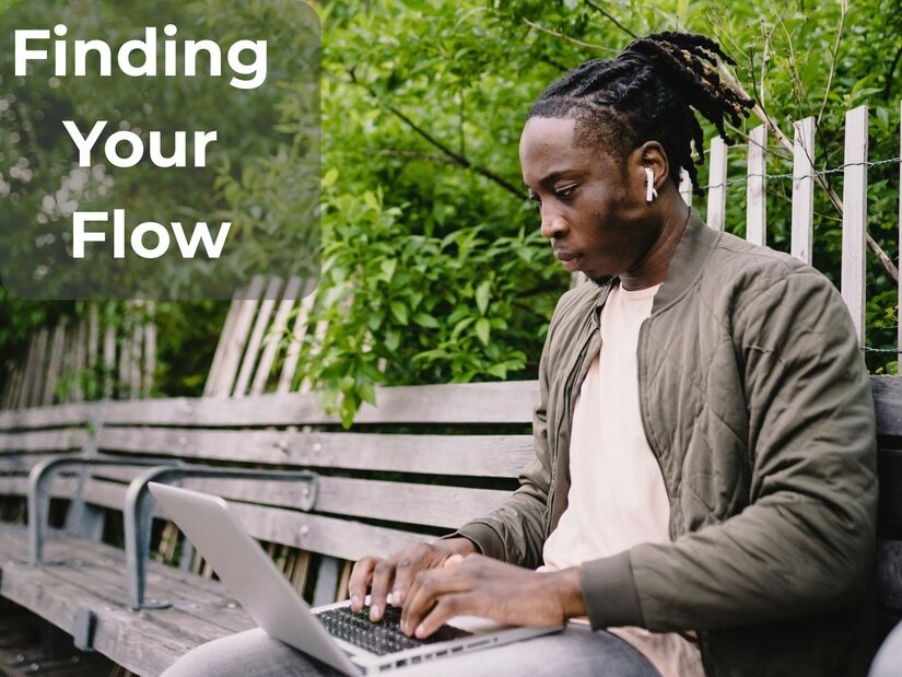 Man in deep concentration working on laptop outdoors in natural environment with greenery demonstrating flow state during optimal focus session with calm engaged expression