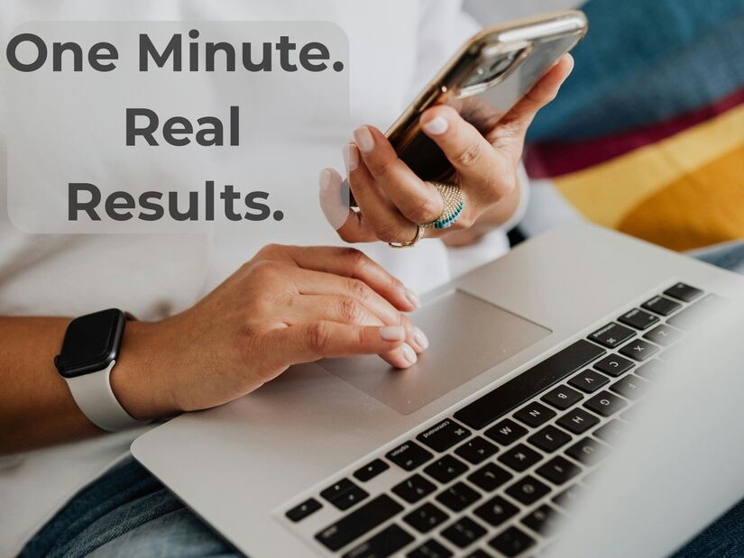 Close-up of a focused person using a smartphone and laptop, managing time-sensitive tasks in a casual setting.