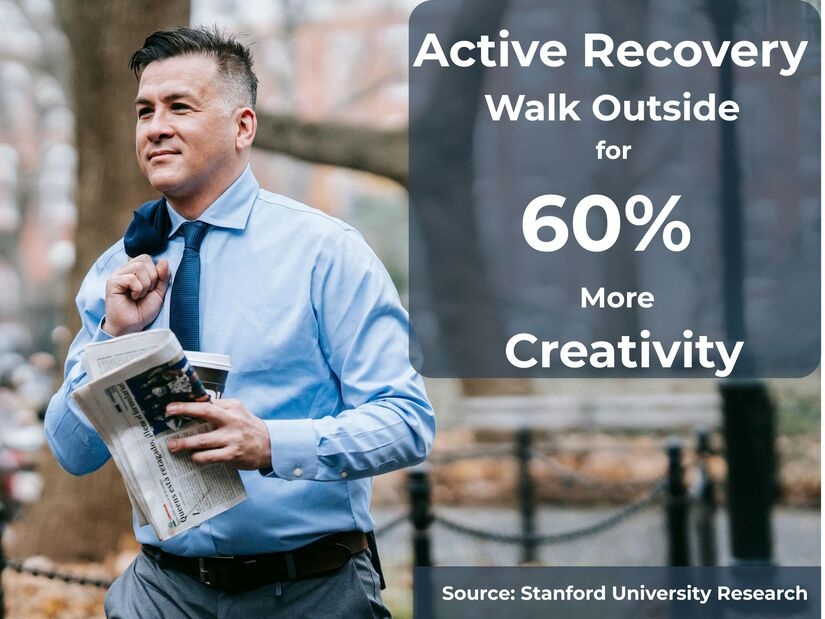 Professional businessman walking outside in nature during active recovery break showing 60 percent creativity increase from outdoor walking based on Stanford research
