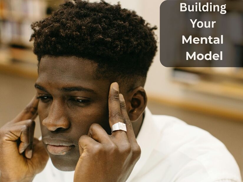 Man in deep concentration with hands on temples showing cognitive effort of building mental model during focused work session

