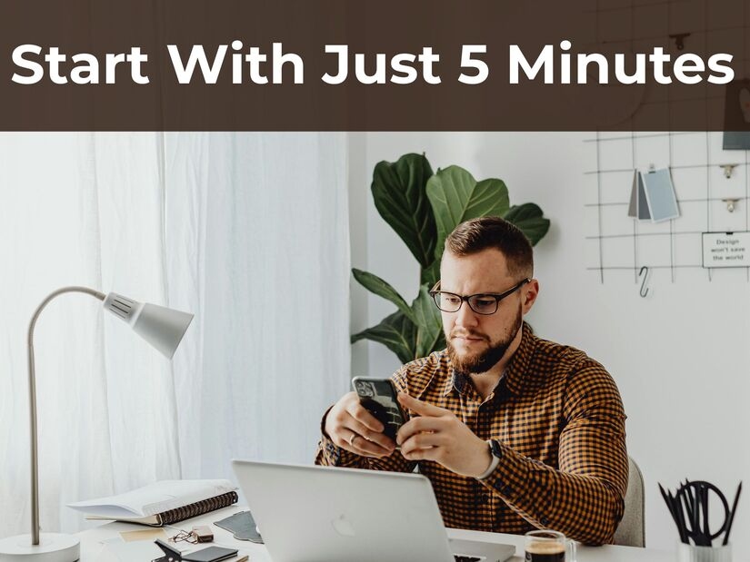 Person setting productivity timer on smartphone before focused work session with laptop