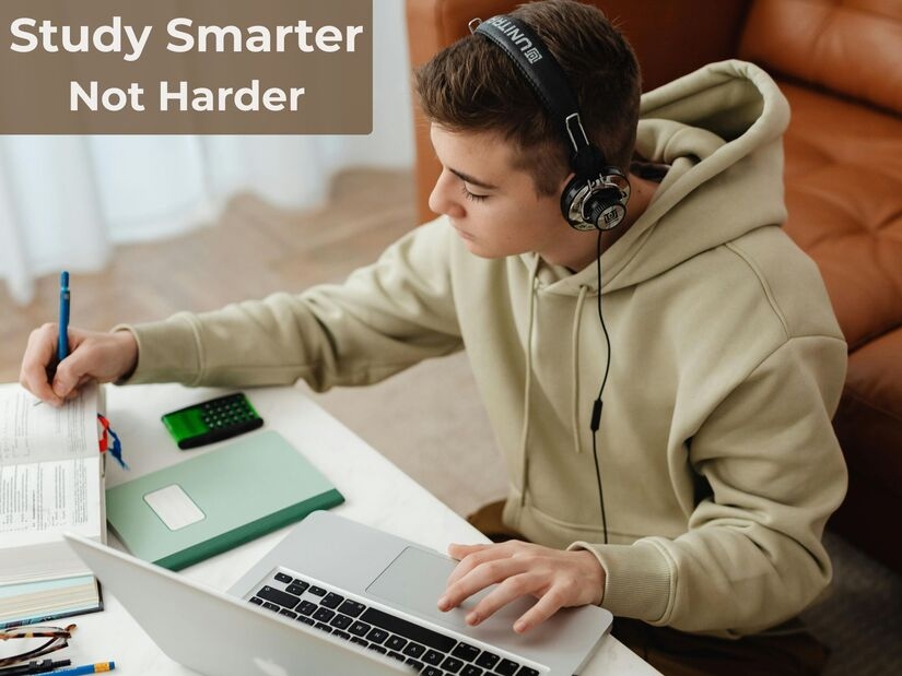 Student using best study techniques with focused attention at organised desk with laptop and notebook