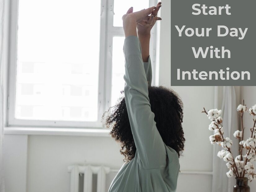 Person doing morning stretch routine by window demonstrating morning routine ideas for an intentional calm start to the day