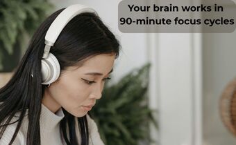 Woman wearing headphones focusing on work to demonstrate a Daily Schedule With Timers and 90-minute focus cycles.