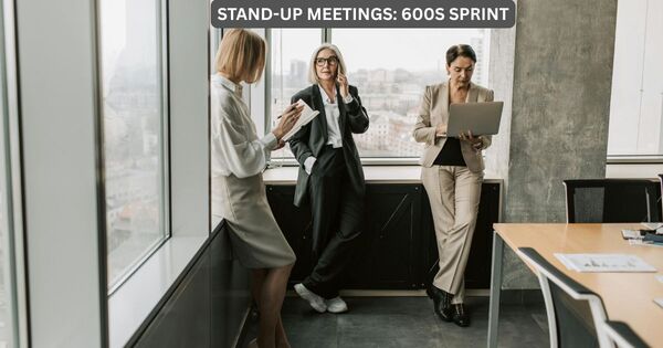 Three diverse professionals in a modern office conducting a high-efficiency standing meeting using a 10-minute timer protocol.