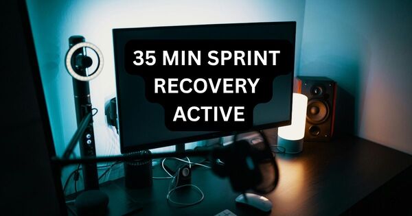 A professional desk setup featuring a digital monitor displaying 35 MIN SPRINT RECOVERY ACTIVE, serving as a visual reminder to use a 35 minute timer for structured productivity and recovery.
