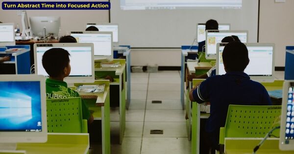 Students working on computers in a modern classroom using an online classroom timer to maintain focus.