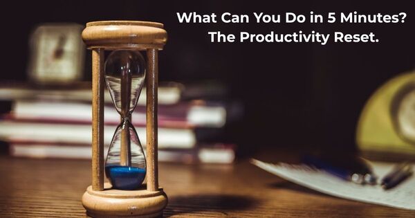 A close-up of an hourglass on a desk, representing the productivity reset technique to answer the question: what can you do in 5 minutes?