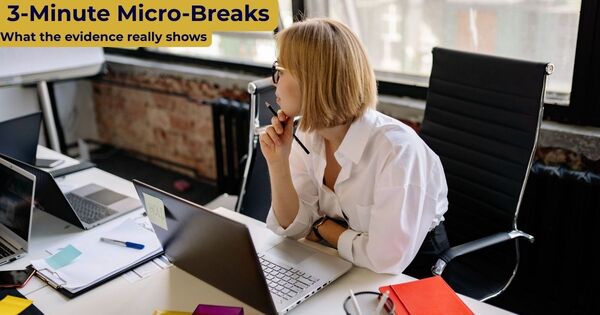 A professional woman taking a brief, reflective pause from her laptop in a modern office environment to illustrate 3 minute micro breaks.